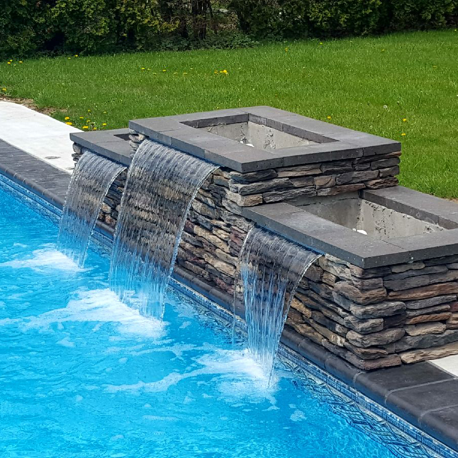 Water from a pool fountain spilling into a pool